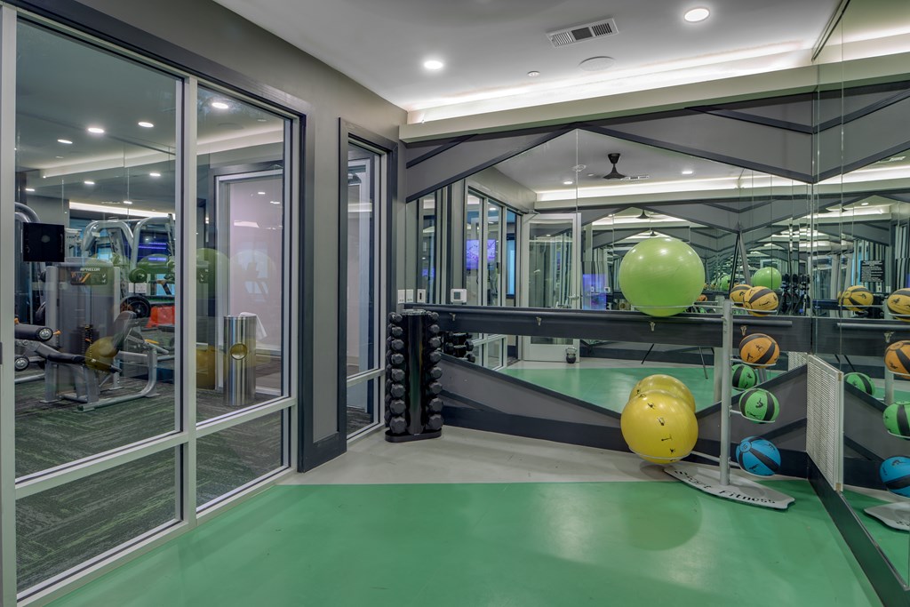 A gym with a green floor and a variety of exercise equipment.