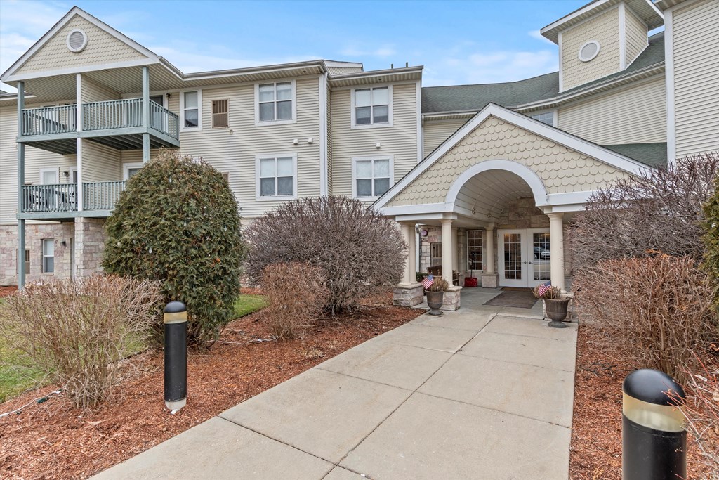 the view of a building with a sidewalk in front of it