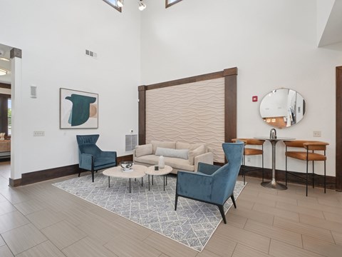 A living room with a blue chair and a white sofa.