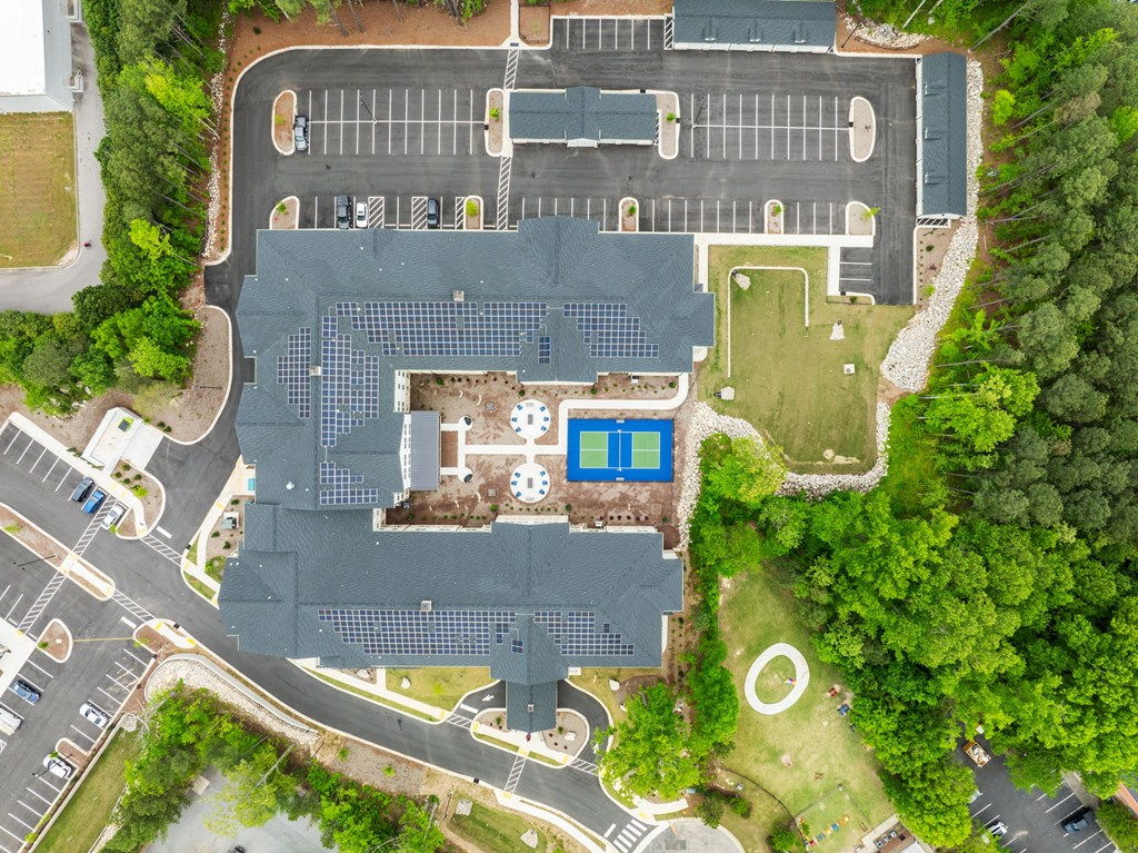 a view of a building from above with a parking lot