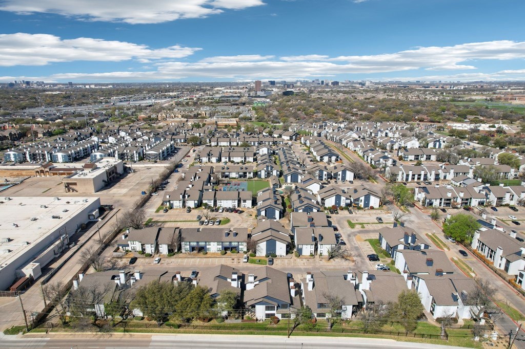 A suburban neighborhood with houses and a large parking lot.