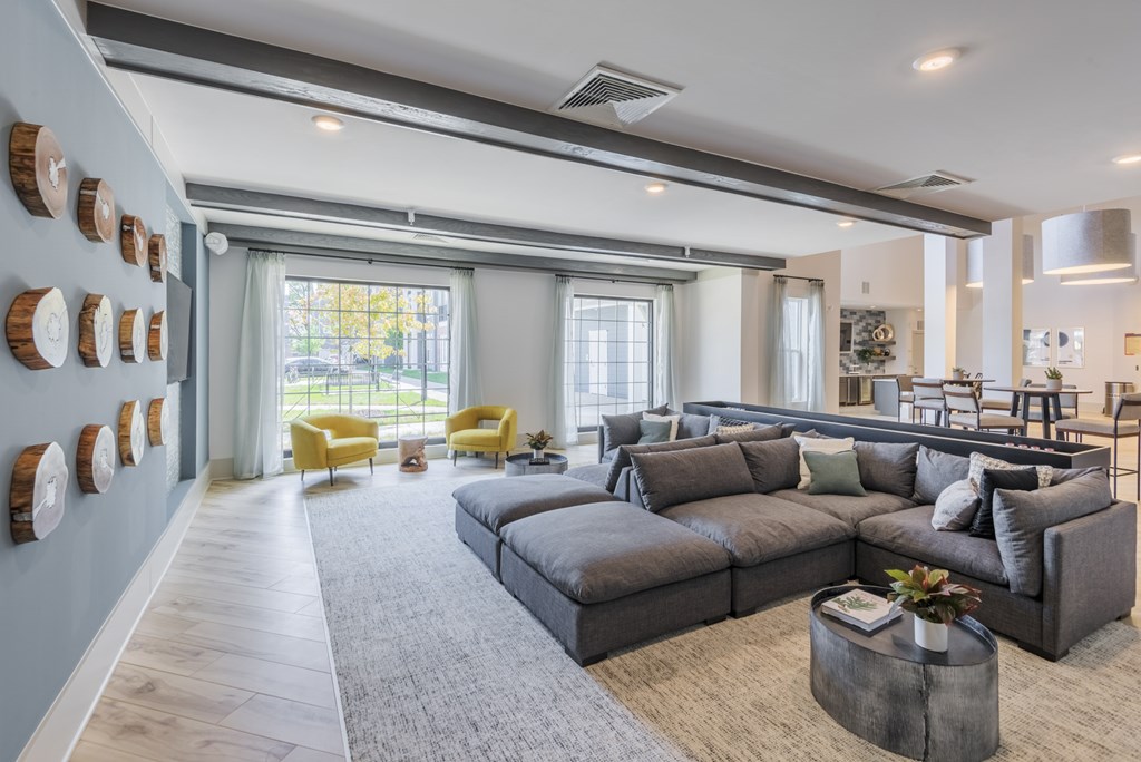 A modern living room with a grey sofa and yellow chairs.