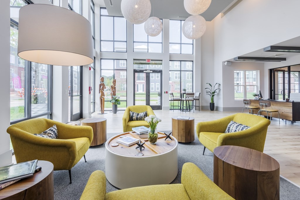 A brightly lit room with yellow chairs and a white table.