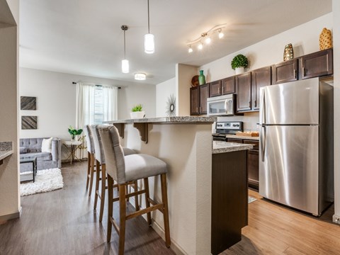 A kitchen with a bar stool in front of the counter.