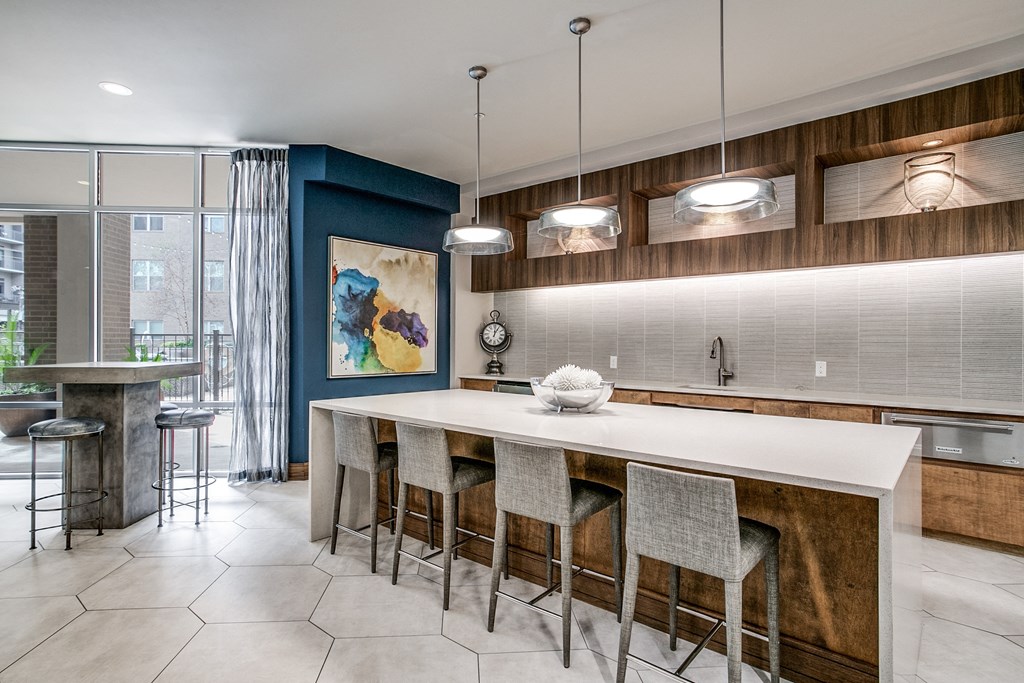 the kitchen has a large island with bar stools and a blue accent wall