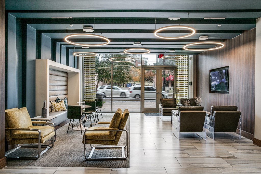 a lobby of a hotel with chairs and a television