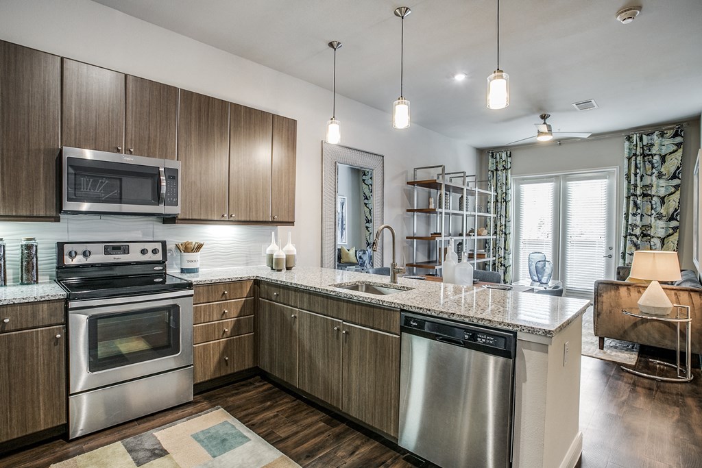 a kitchen with stainless steel appliances and a marble counter top