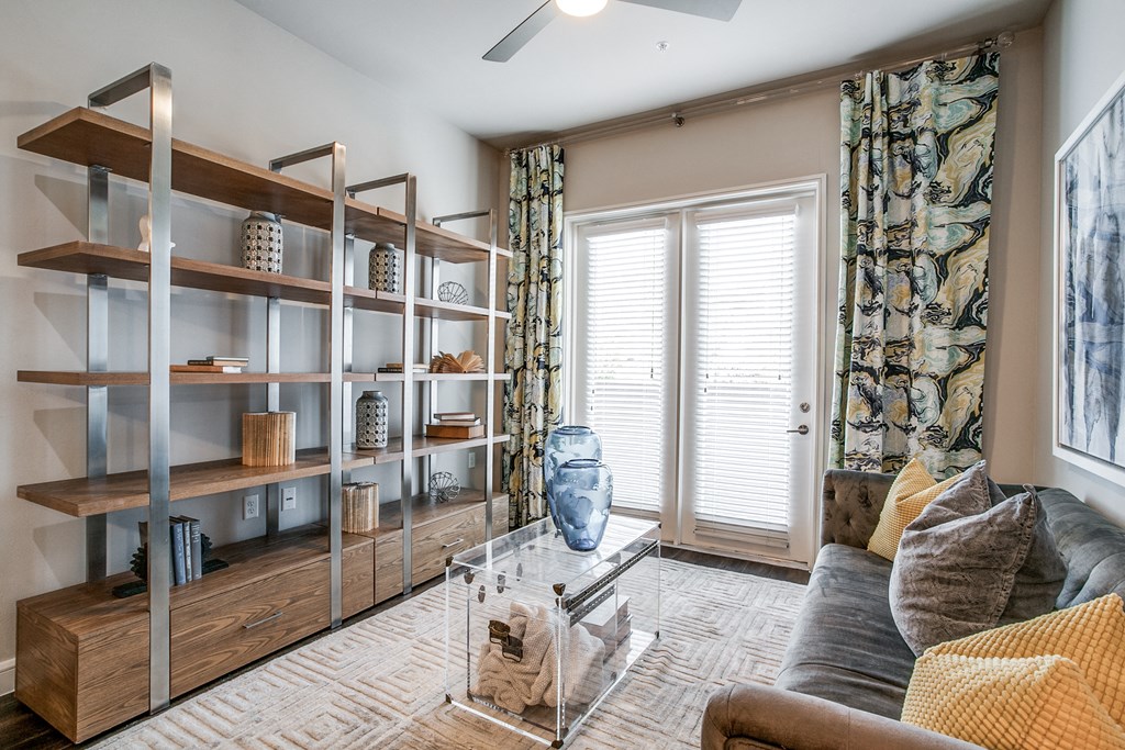 a living room with a couch and a window and shelving