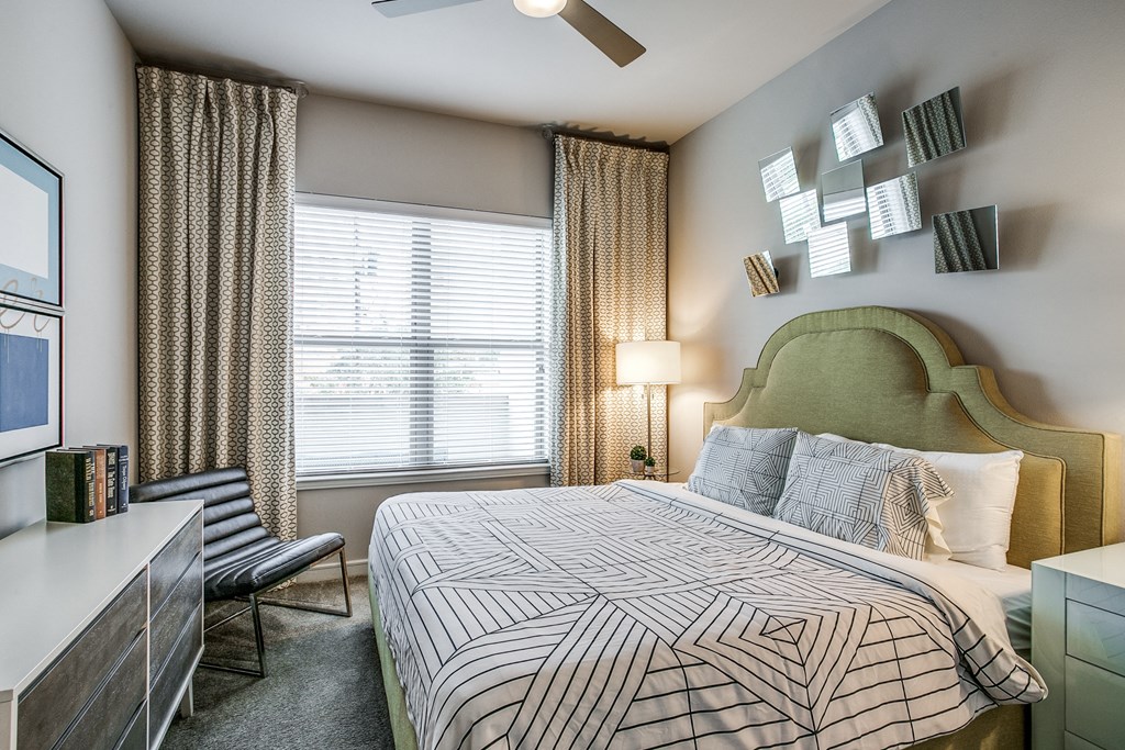 a bedroom with a bed and a dresser and a window