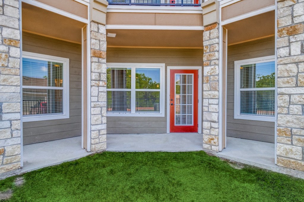 a front porch of a house with a red door
