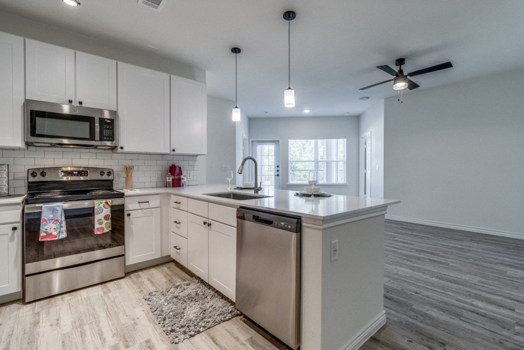 an open kitchen with stainless steel appliances and white cabinets