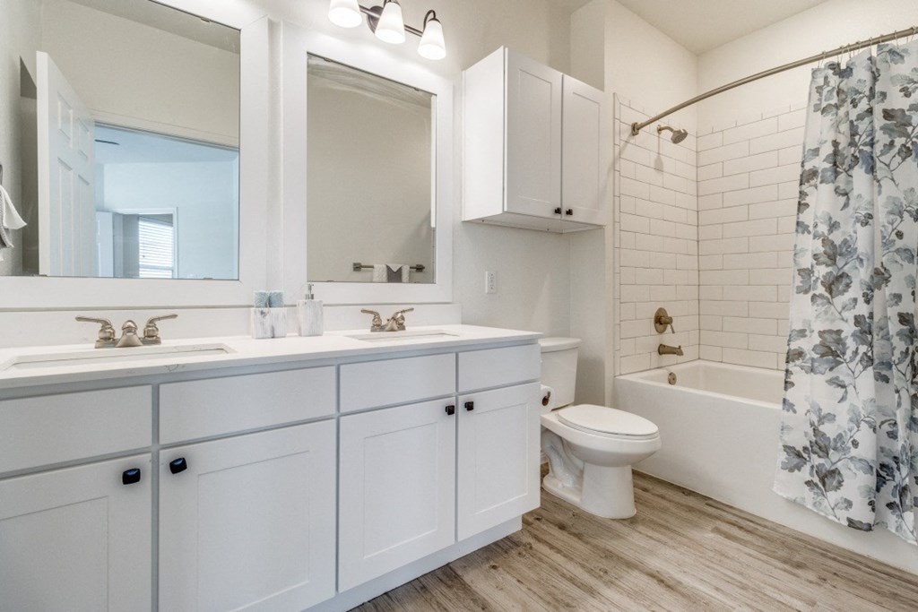 a bathroom with white cabinets and a shower and a toilet