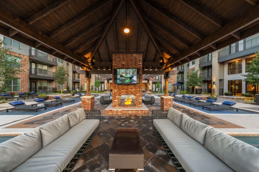 a lounge area with couches and a fireplace in the middle of an apartment building