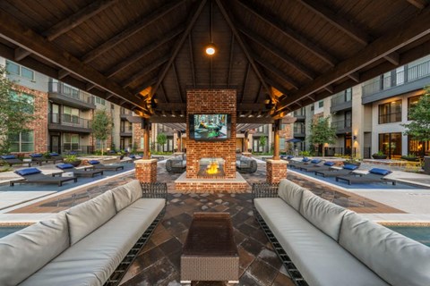 a lounge area with couches and a fireplace in the middle of an apartment building