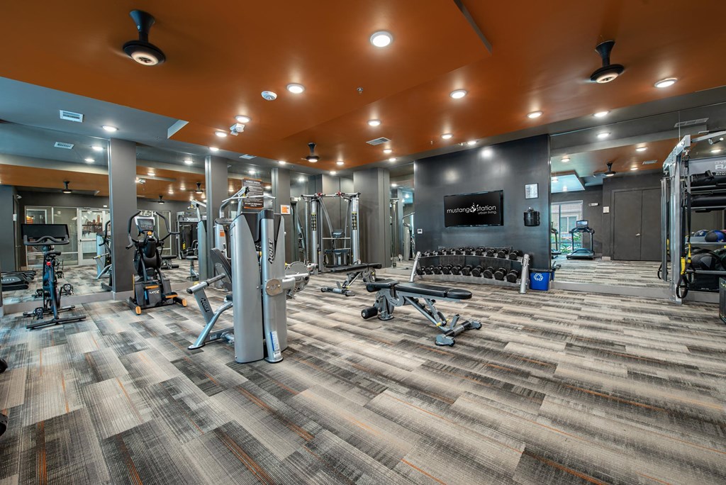a gym with weights and cardio equipment in a building