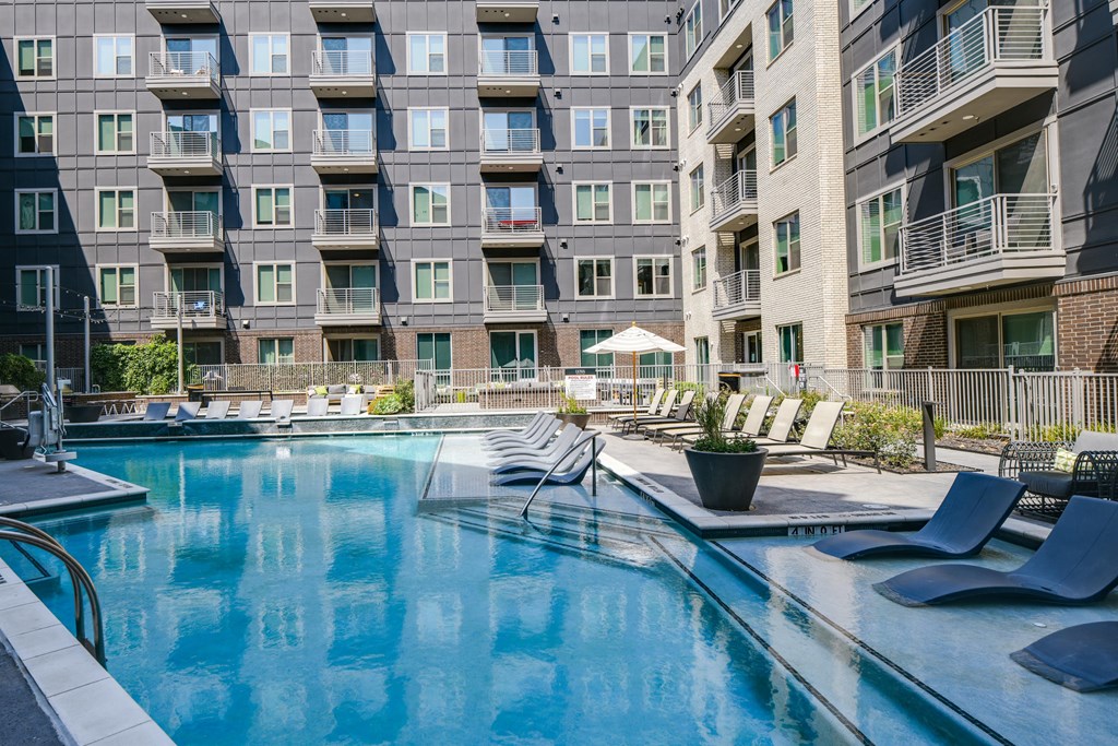 A large swimming pool in front of apartment buildings.