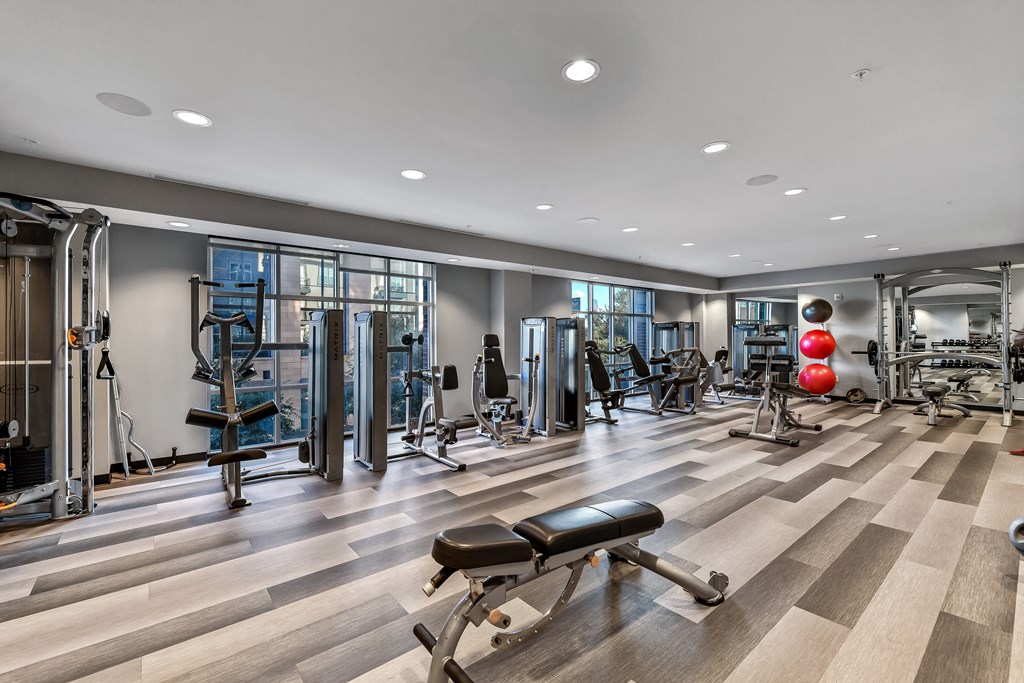A gym with a variety of equipment including treadmills, weights, and exercise machines.