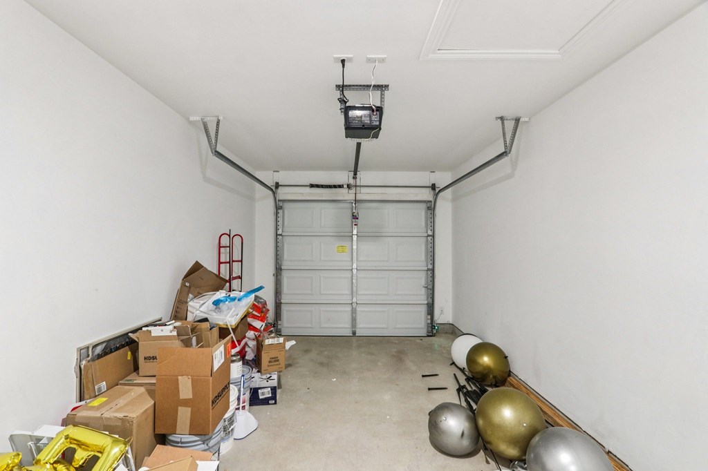 A room with a white wall and a white door is filled with boxes and bags.