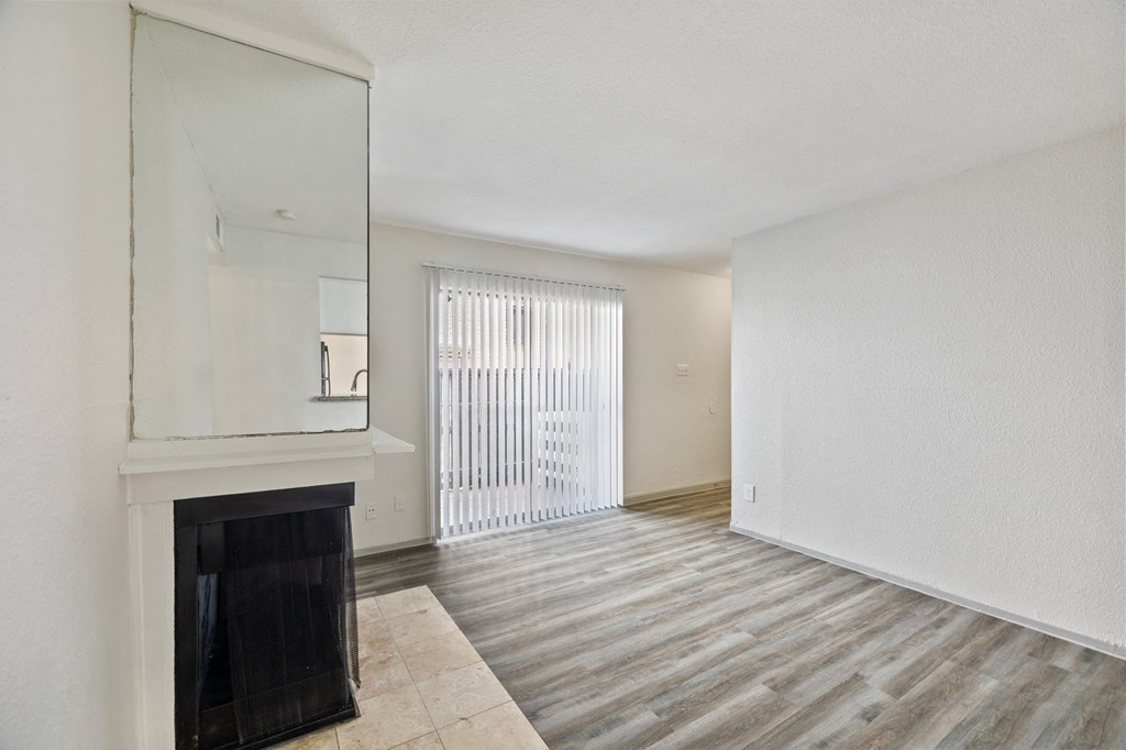 an empty living room with a fireplace and a window