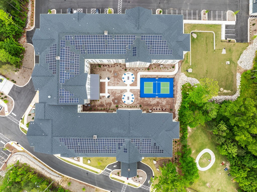an overhead view of a house with a tennis court and a pool