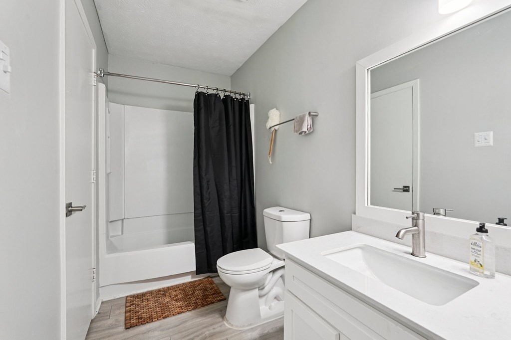 A bathroom with a toilet, sink, and shower.