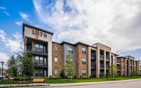 an apartment building with a bench in front of it