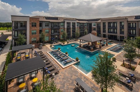 an overhead view of an apartment complex with a swimming pool