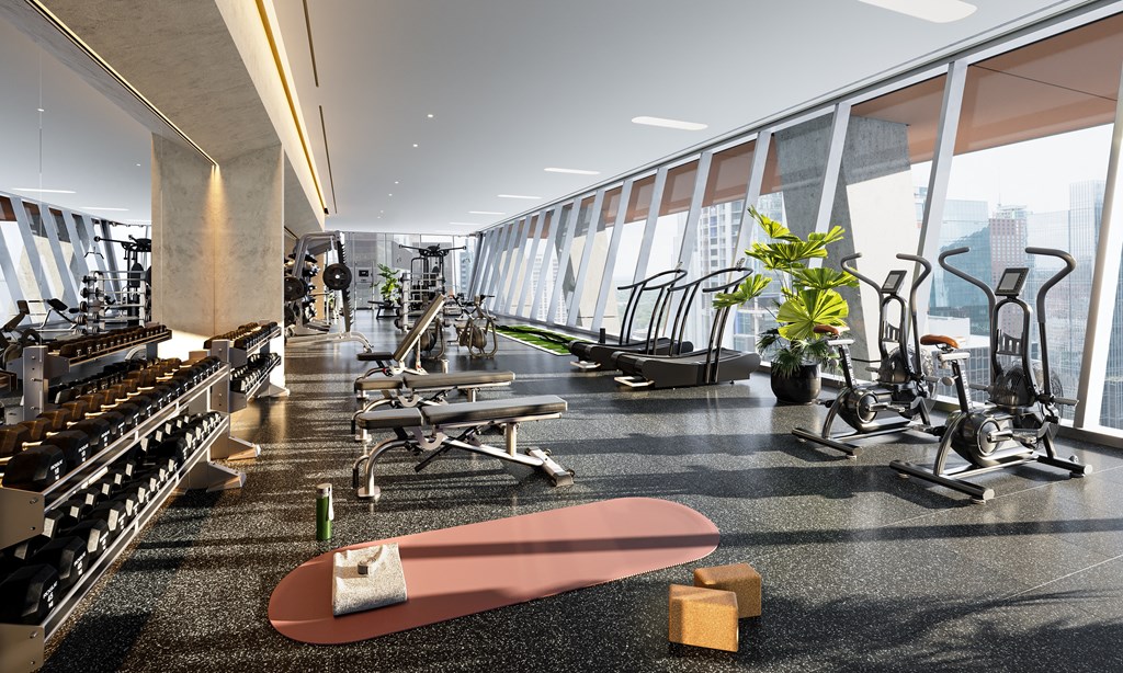 a gym with weights and cardio equipment and a skateboard on the floor