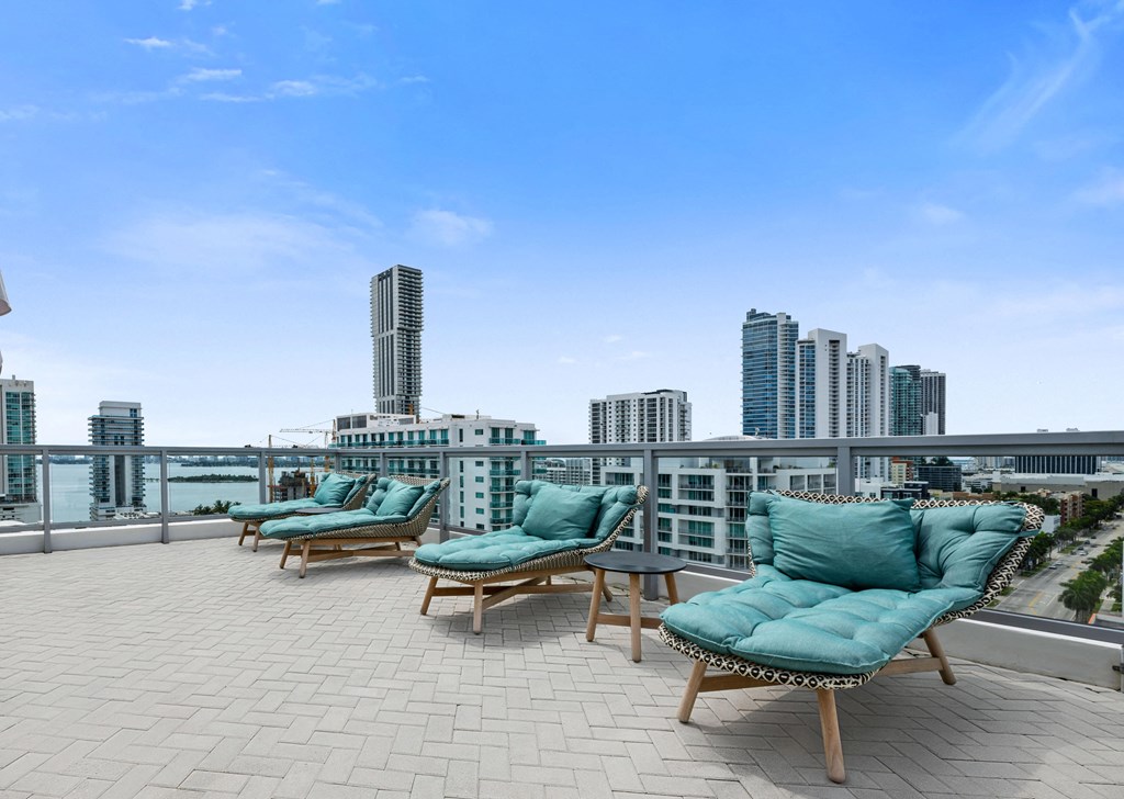 an outdoor terrace with lounge chairs and a view of the city