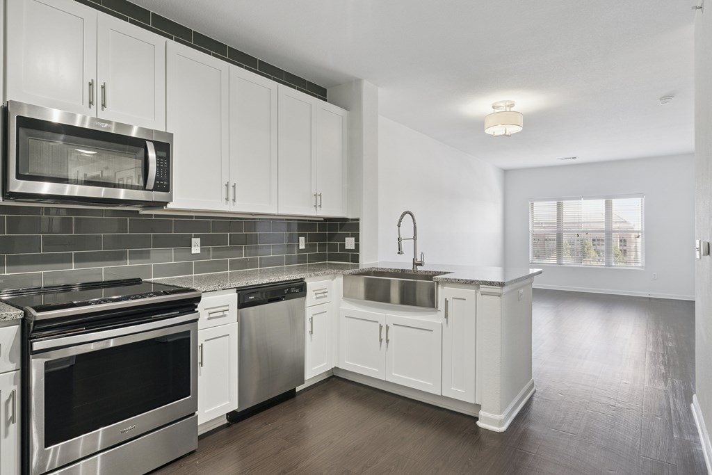 A kitchen with white cabinets and stainless steel appliances.