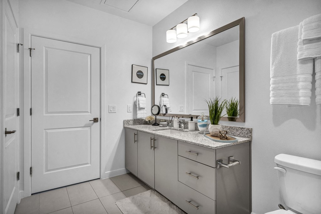 a bathroom with a large mirror and a toilet and a sink