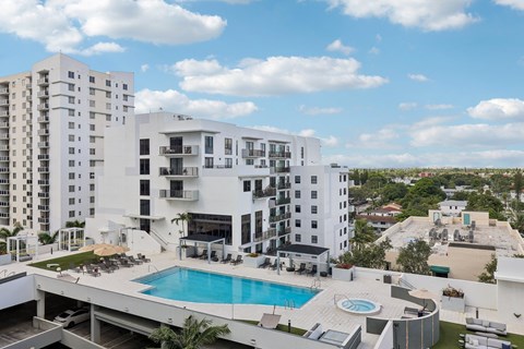 A large white building with a pool in the foreground.