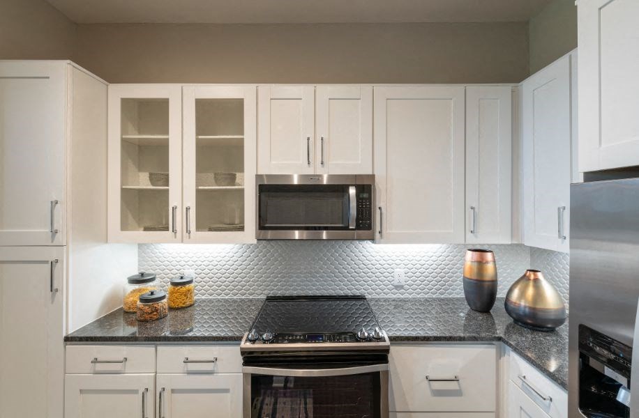 a kitchen with white cabinets and a stove and a microwave
