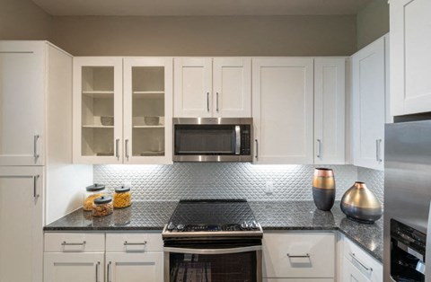 a kitchen with white cabinets and a stove and a microwave