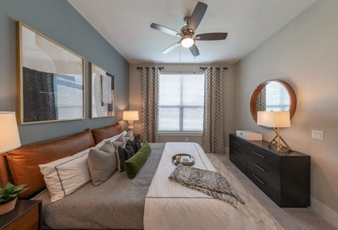 a bedroom with a large bed and a ceiling fan