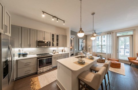 a kitchen and living room with a table and chairs