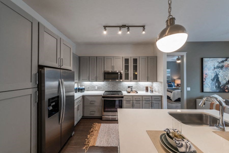a kitchen with stainless steel appliances and white counter tops