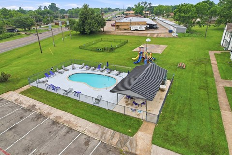 A pool with a slide and a building in the background.