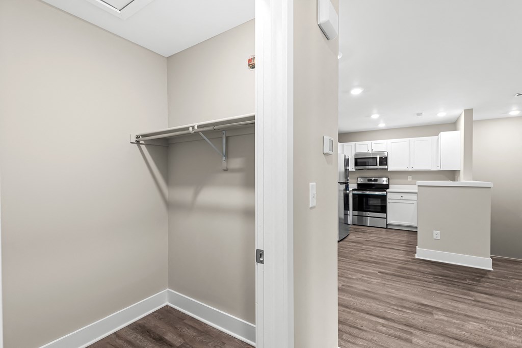 a renovated living room with a closet and a kitchen