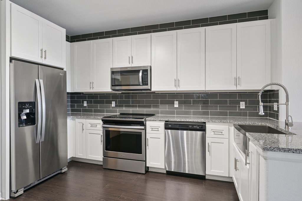 A kitchen with white cabinets and stainless steel appliances.
