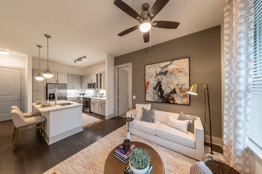a living room and kitchen with a ceiling fan