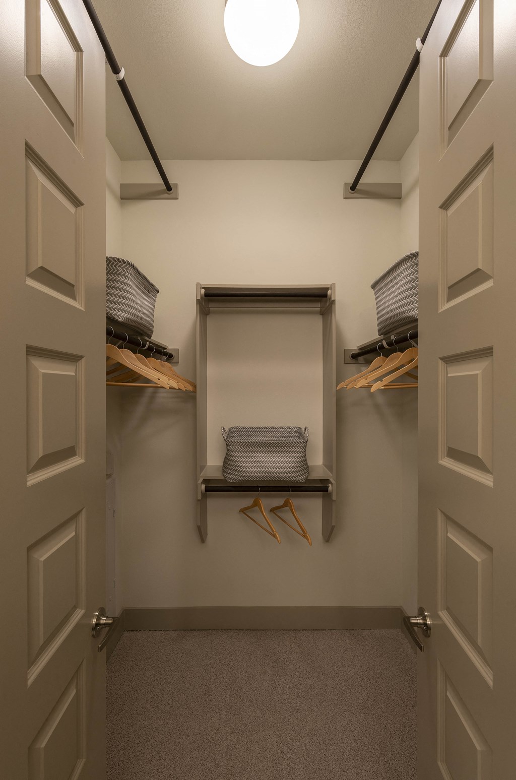 a walk in closet with white walls and two white doors