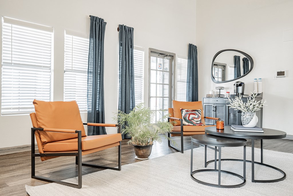 a living room with orange chairs and a coffee table