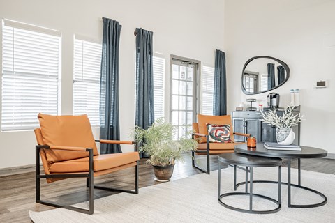 a living room with orange chairs and a coffee table