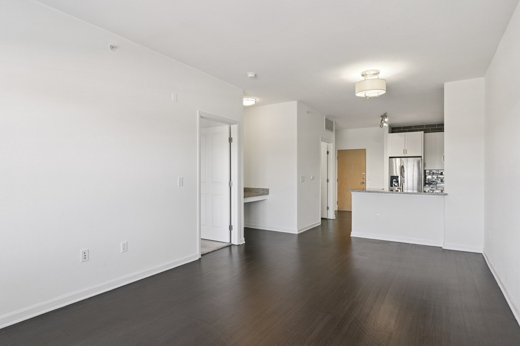 A large empty room with wooden floors and white walls.