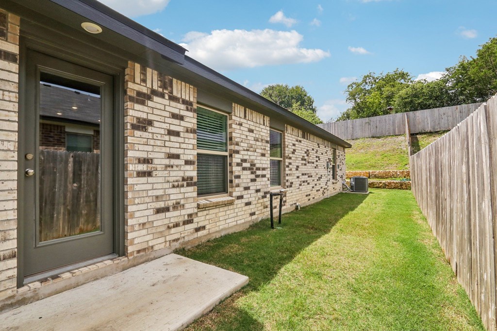 A house with a grey door and a window with a green frame.