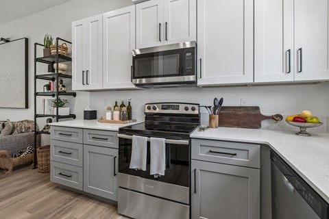 A modern kitchen with a stainless steel oven and white cabinets.