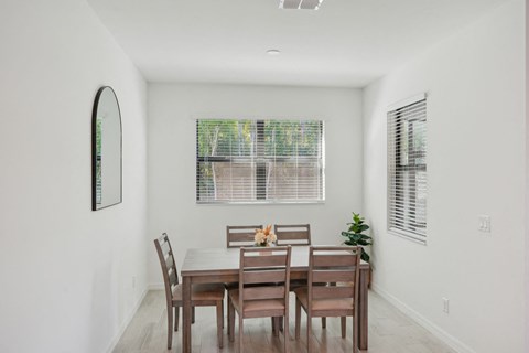 A dining room with a table set for six.