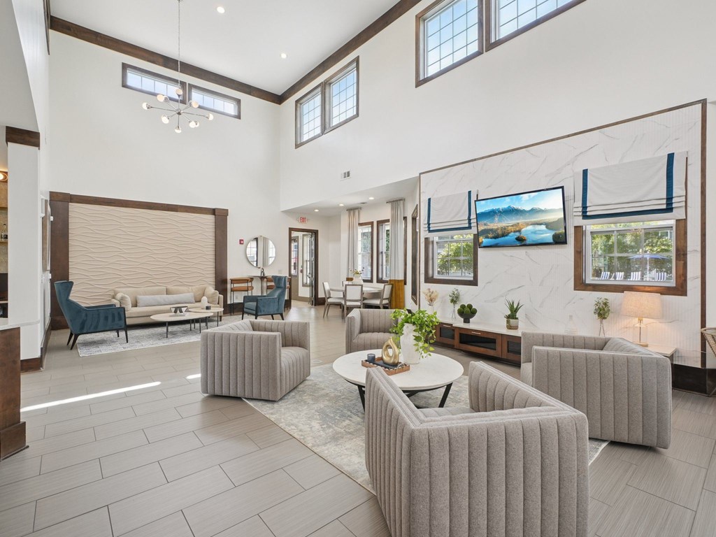 A spacious living room with a large grey sofa set and a coffee table in the center.