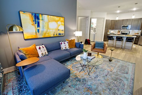 Spacious living room with a blue couch and a table